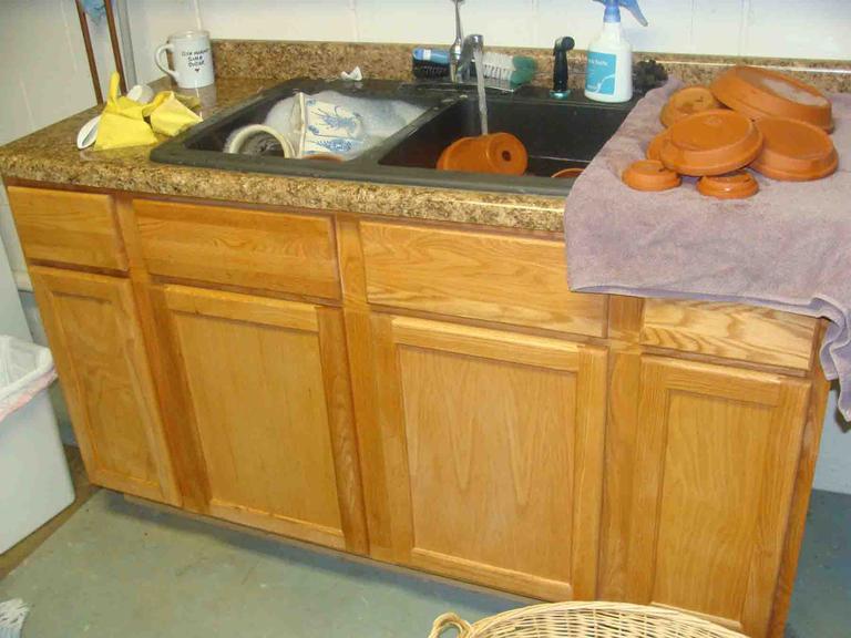 When cleaning and sanitizing garden tools and pots, it is best to have a washing sink, a rinsing sink and a third area where cleaned dishes can be spay sanitized with bleach and sit to dry.
