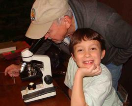 Child and grandfather with microscope